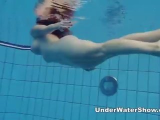 Redheaded divinity nadando desnuda en la piscina
